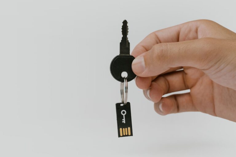 Telefon mobil și o cheie de securitate fizică așezate pe un birou