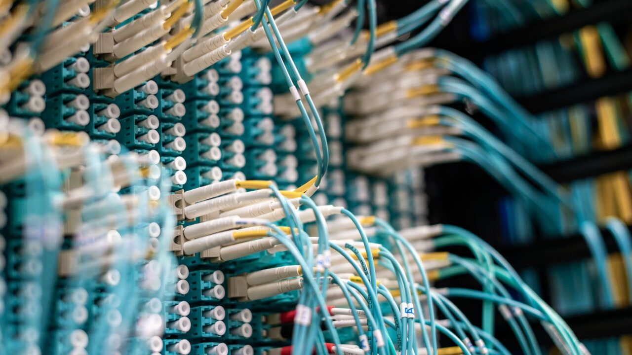 Cabluri de rețea conectate la servere într-un centru de date, simbol al fluxului de informații