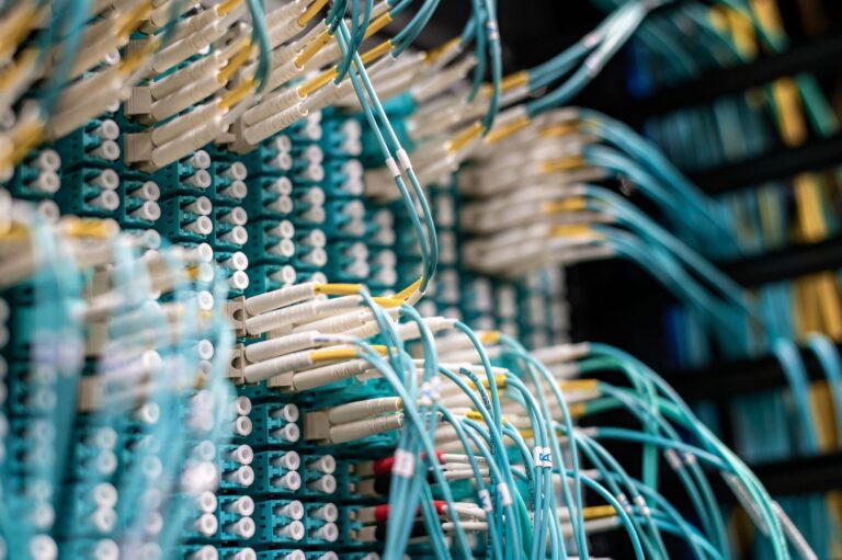 Cabluri de rețea conectate la servere într-un centru de date, simbol al fluxului de informații